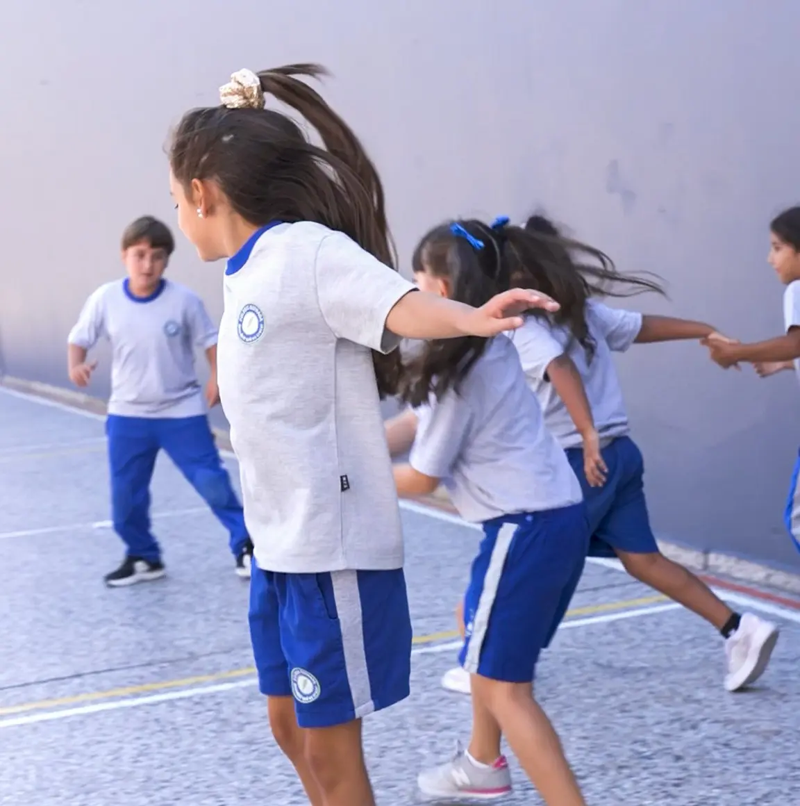 Alumnos del Nivel Inicial del Colegio Estrada participando en actividades de juego, movimiento y desarrollo motriz en el patio escolar.
